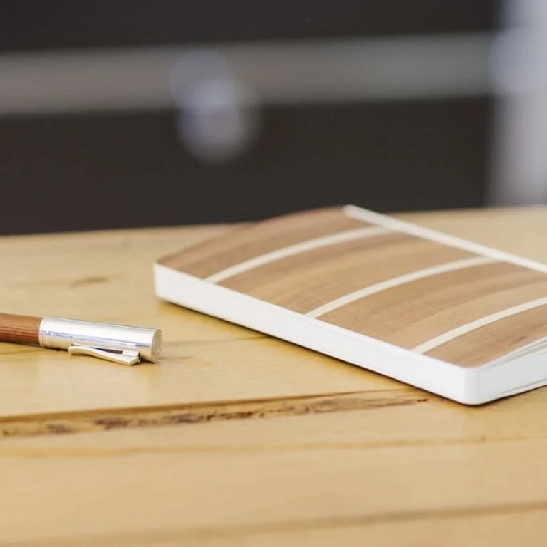 Holzschreibtisch mit Stift und Notizbuch